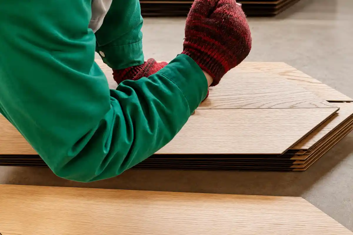 Worker checking SPC flooring surface and locking quality