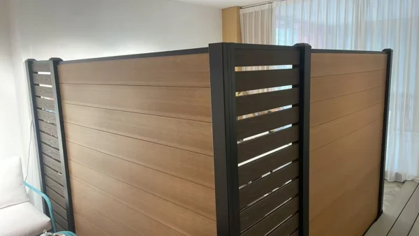 Composite fence panels finished with aluminum top rails, posts and post caps