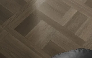 Grey wood-look square LVT flooring with a repeating framed pattern in a furnished room