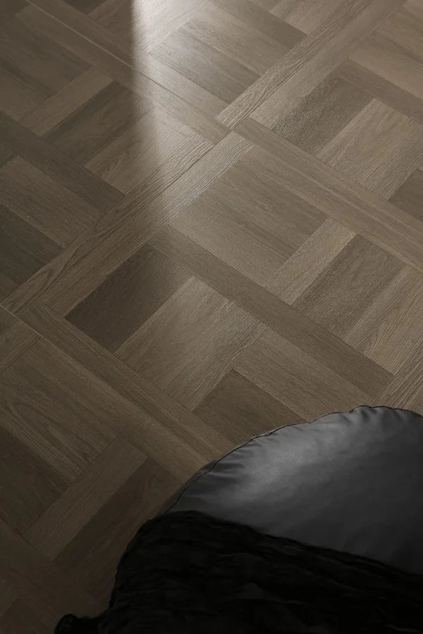 Grey wood-look square LVT flooring with a repeating framed pattern in a furnished room