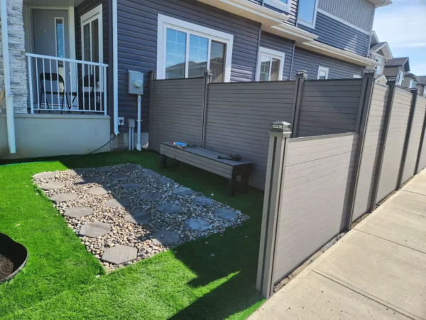 Grey WPC privacy fence installed around a residential garden